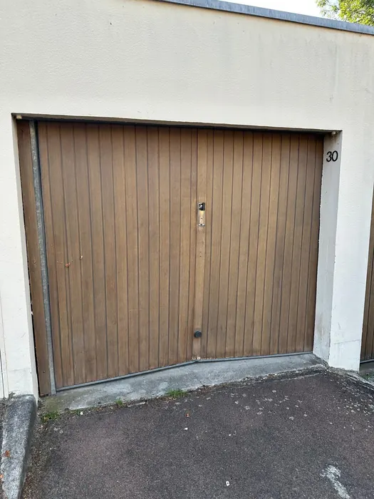 Avant : Ancienne porte en bois remplacée par une porte basculante neuve