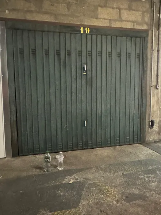 Avant : Porte métallique abîmée remplacée par une porte basculante blanche