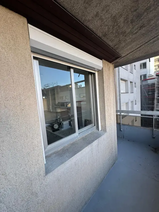 Volet roulant blanc avec coffre sur une fenêtre coulissante, réalisation ERM Service